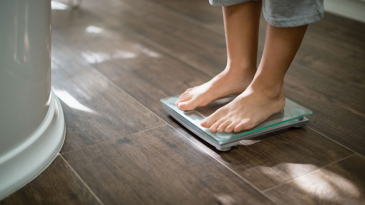 boy-checking-his-weight-on-weight-scale-VSBPYXG.jpg